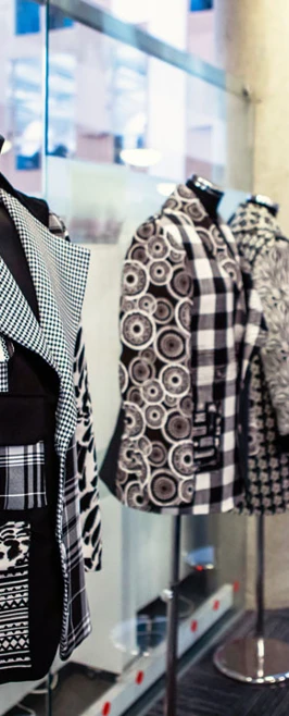 Mannequins displaying unique black and white fashion designs in a college exhibition space. Mannequins displaying unique black and white fashion designs in a college exhibition space.